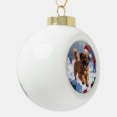 雪の中でチベッ走トのマスチフのクリスマス帽子と セラミックボールオーナメント (左)