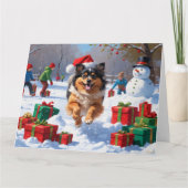 雪の中で走Keeshond Dog Hatとクリスマスハット カード (正面)