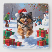 雪の中で走Keeshond Dog Hatとクリスマスハット スクエア壁時計 (正面)