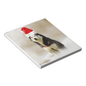 雪の中にサンタハットを持つシベリアのハスキー犬 ノートパッド (アングル)