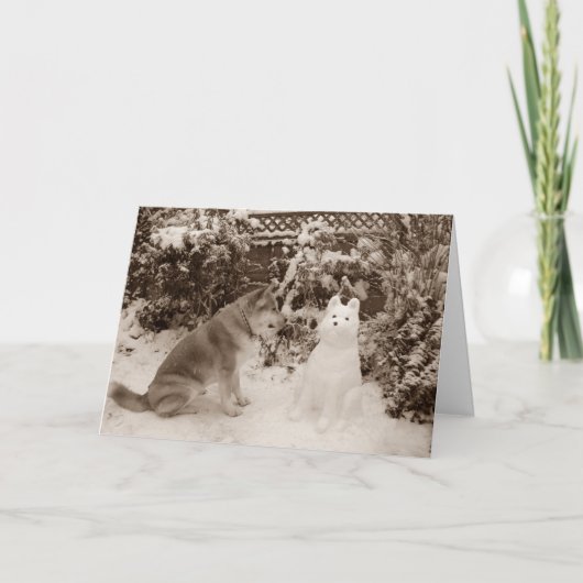 雪の中に座った可愛い秋田と雪だるま犬 シーズンカード (正面)