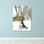 雪の中に座った犬がログキャビンを後ろに置いて キャンバスプリント (インサイチュ (ウッドフロア))