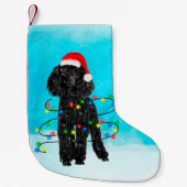 雪の中に座ってサンタ帽子の灯りを持つプードル犬 スモールクリスマスストッキング (正面)
