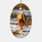 雪の中に茶色とクリームのミニチュアホース。 セラミックオーナメント (左)