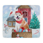 雪の中の秋田犬のクリスマスドッグハウス カッティングボード (正面)