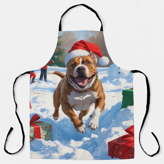 雪の中を走るクリスマス帽のピットブル犬 エプロン (正面)