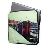 雪の中、青と黄色の列車 ラップトップスリーブ (正面左)