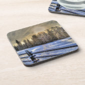 雪の冬の牧草地での日の出 コースター (左側)