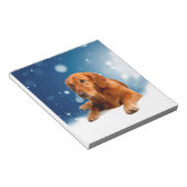 雪の星に座る、かわいいゴールデンレトリバー犬 ノートパッド (アングル)