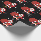雪片と星のクリスマスを持つ黒いサンタ ラッピングペーパー (角)