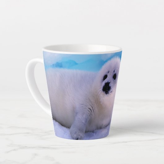 雪片に覆われた小さなハープのアザラシ カフェラテマグ (左アングル)