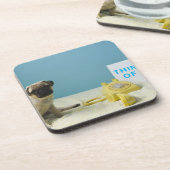 電話の隣にベッドに坐っているパグの子犬 コースター (左側)