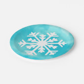 青い水の色の背景に白いスノーフレーク ペーパープレート (アングル)