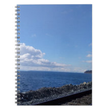 青い空の下で海辺と列車の線路