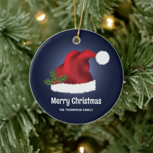 青い背景にクリスマスホーリー付きの赤いサンタ帽子 セラミックオーナメント (ツリー)