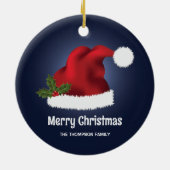 青い背景にクリスマスホーリー付きの赤いサンタ帽子 セラミックオーナメント (裏面)