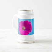 青い背景にピンクのペチュニアの花。 ビールジョッキ (正面左)