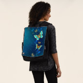 青い背景に浮かぶ金色の蝶 バックパック (着用)