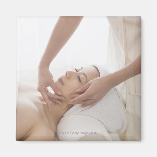 顔をマッサージしている若い女性 マグネット (正面)