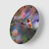 飛んでいるなハチドリおよびカラフルの背景 ラウンド壁時計 (傾斜)