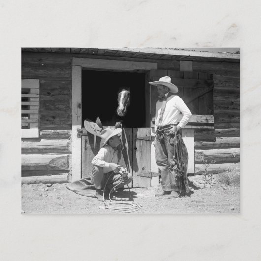 馬が付いている納屋の隣に立っている2人のカウボーイ ポストカード (正面)