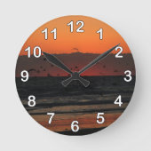 鳥が飛んでいる海の日の出の写真 ラウンド壁時計 (正面)