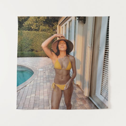 黄色いビキニ姿の女性が茶色のれんが色の床の上に立っている タペストリー (正面)