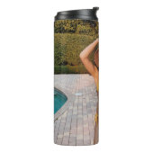 黄色いビキニ姿の女性が茶色のれんが色の床の上に立っている タンブラー (回転左)