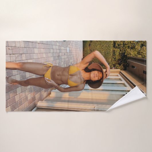 黄色いビキニ姿の女性が茶色のれんが色の床の上に立っている バスタオル (バスタオル)