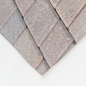 黄色いビキニ姿の女性が茶色のれんが色の床の上に立っている フリースブランケット (角)