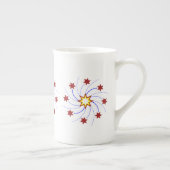 、黄色い赤い、花火の星の渦巻-白で青い ボーンチャイナマグカップ (右)