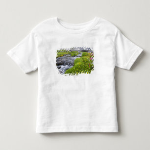 黄色く白いピンクの野生の花が付いているぼやけた川 トドラーTシャツ