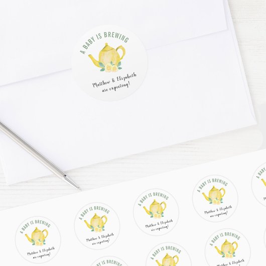 黄色のティーポットを醸造しているベビーを期待している ラウンドシール