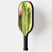 黄色のピックルボールパドルに載った3つのキュウリ ピックルボールラケット (左)