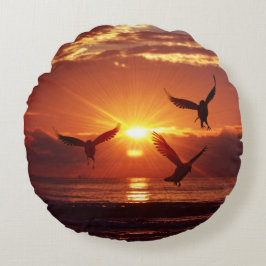 黄金の飛んでいる夕焼けの下のカモメ ラウンドクッション