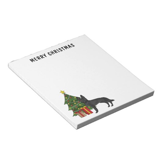 黒いドイツの羊飼いとフェスティバルクリスマスツリー ノートパッド (アングル)