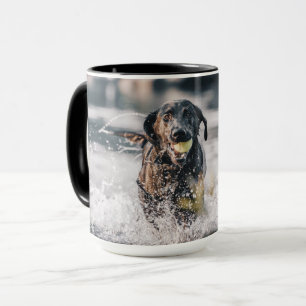 黒いラブラドールが水に入る マグカップ