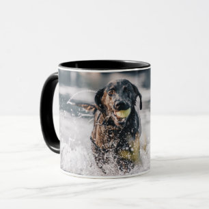 黒いラブラドールが水に入る マグカップ