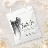黒いリボンで結ばれたウェディングシャワーの感謝を伝える フェイバーバッグ (クリップ留めされた状態)