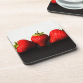 黒いcoastercn Beveragの上に白のイチゴ コースター (左側)