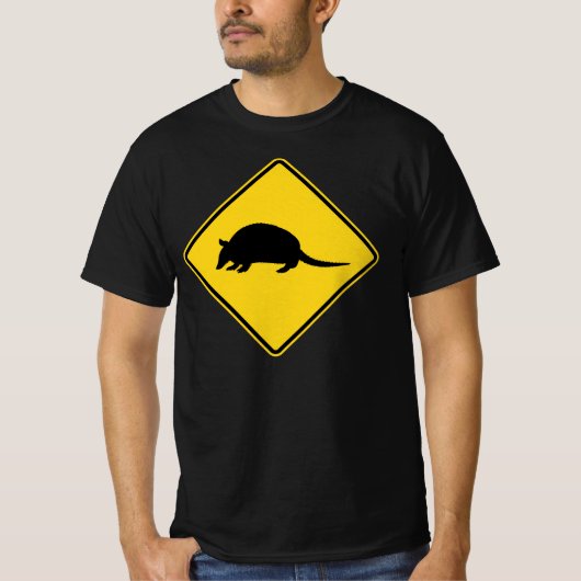 黒と黄色のアルマジロが道路標識を横切る Tシャツ (正面)