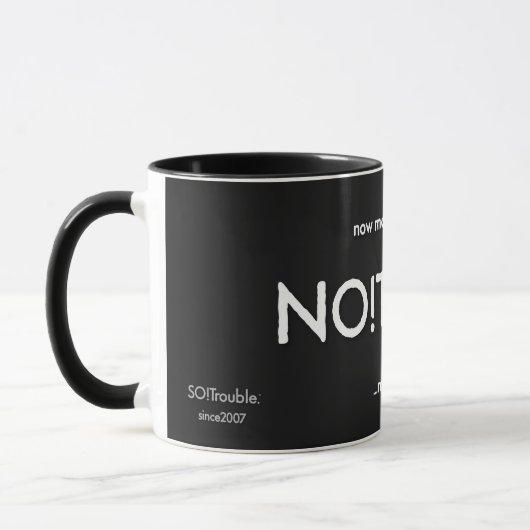 黒地にタグラインが白で映えるNO!Trouble マグカップ (左)