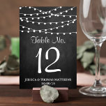 黒板の上に糸が結婚灯る テーブルナンバー<br><div class="desc">まシンプルたエレガント、結婚chalkboardのコレクションのストリングライトは素晴らし、お祝いに最適なchalkboard効果背景に美しい白のストリングライトを搭載したデザインでぶら下がったす。これらのテーブル番号カードはパーソナライズされた、あなたの特別な機会のために使用することができ、あなたの結婚、ブライダルシャワー、婚約パーティ、誕生日パーティーや多くの特別な機会のために完璧なテーブルカードを作る。デザインの右側カスタムにある[このデザインテンプレートを編集する]ボックスまたは青い[文字を編集すクリックる]ボタンを使用しての配置を行うと、フォントと色を変更しカスタマイズて、このデザインに追加の情報や画像を追加します。***ご注文方法***おカスタマイズして、各テーブル番号カードをカートに1枚ずつ追加する。Zazzleは現在、注文された後に製品の任意のカスタマイズを許可するシステムを持っていない。</div>