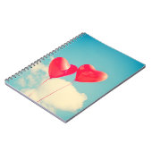 2つの明るい赤いハート型の風船が浮かび上がる ノートブック (左側)