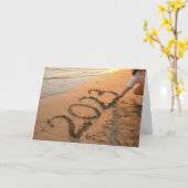 2023年 幸せな新年、ビーチの砂に書く カード (黄色い花)