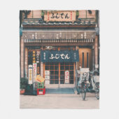 3台の自転車を前に置く建物 フリースブランケット (正面)