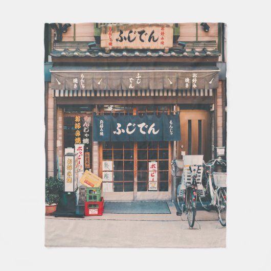 3台の自転車を前に置く建物 フリースブランケット (正面)