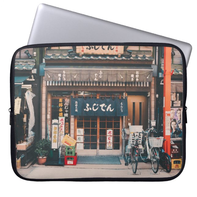 3台の自転車を前に置く建物 ラップトップスリーブ (正面)