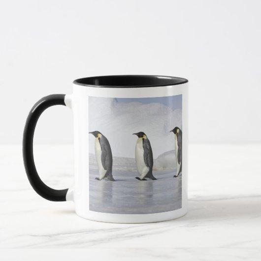 3羽のコウテイペンギン、雪の丘の島 マグカップ (左)