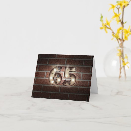 65th誕生日マーキーがレンガの壁に点灯 カード (黄色い花)